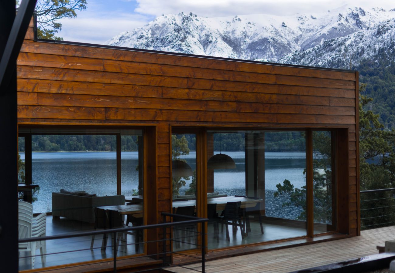 Vista externa do Salão de Usos Múltiplos do Suites del Lago com vista para o lago e as montanhas nevadas em Bariloche.