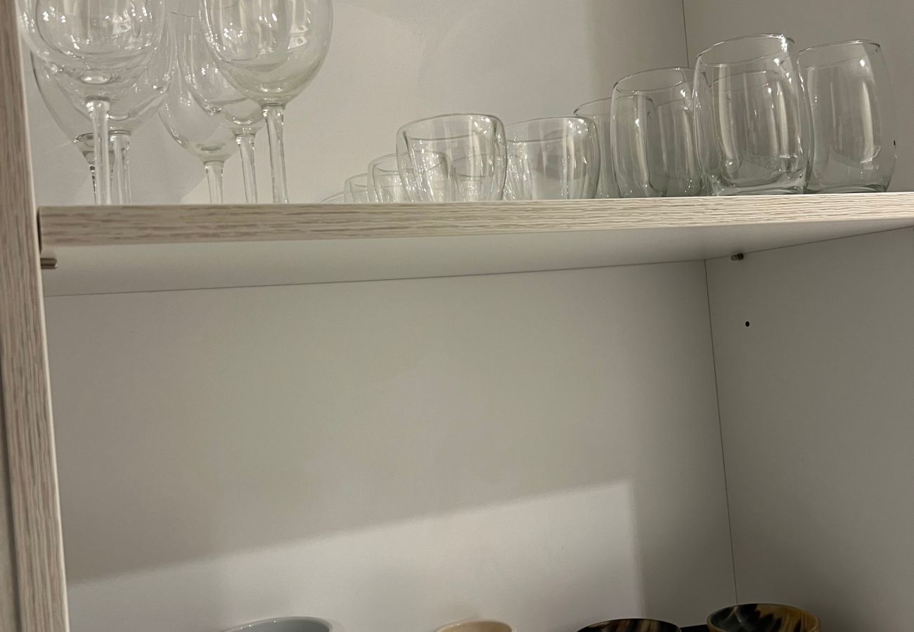 Kitchen detail in Arrayán 1A apartment with tableware, cutlery, and cooking utensils for guests.
